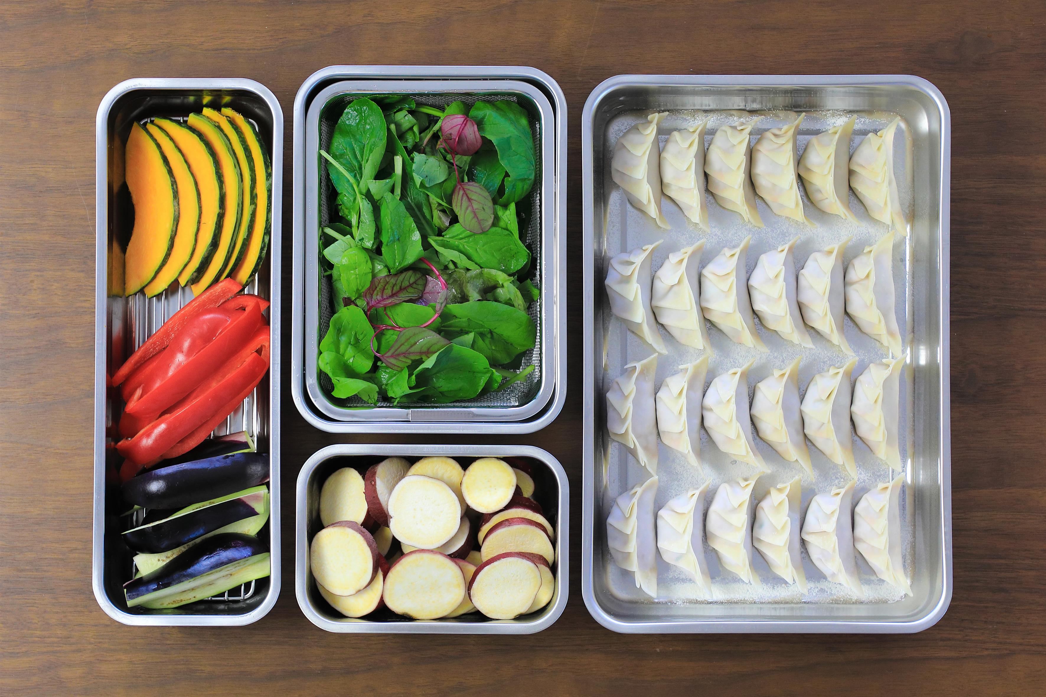 KAJIdonya cooking tray system holding vegetables, greens and dumplings during food preparation.